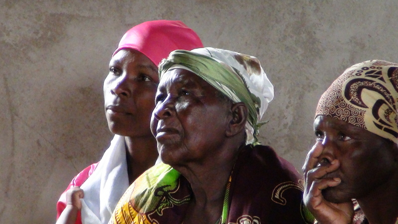 Oude Simbiti-vrouwen luisteren vol belangstelling naar de preek van dominee Waynse
